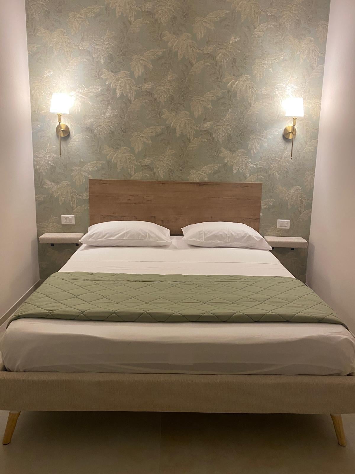 Camera matrimoniale con letto e lampade a parete
